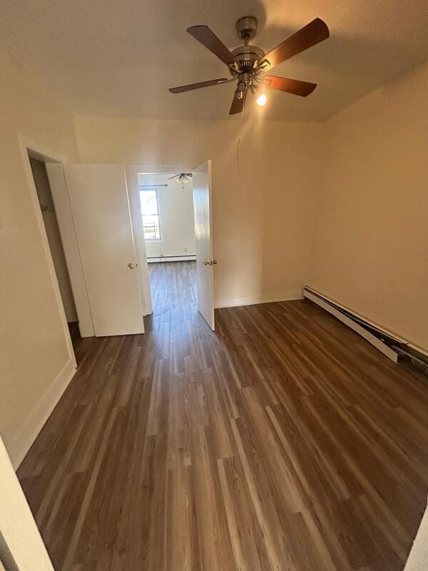 spare room featuring dark wood-style floors, baseboards, and baseboard heating