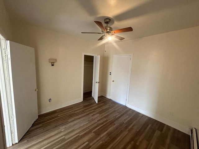 unfurnished bedroom featuring a closet, dark wood-style flooring, ceiling fan, and baseboards