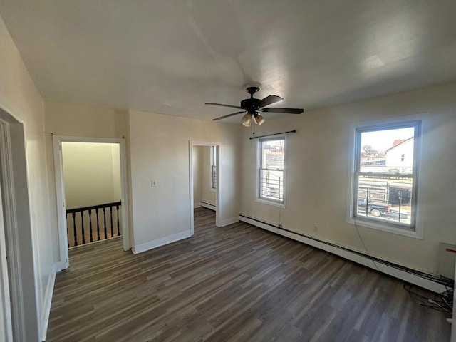 unfurnished bedroom featuring ceiling fan, dark wood-style flooring, baseboard heating, and baseboards