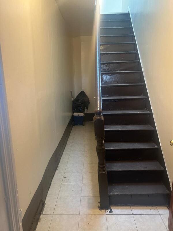 stairway with tile patterned flooring and baseboards