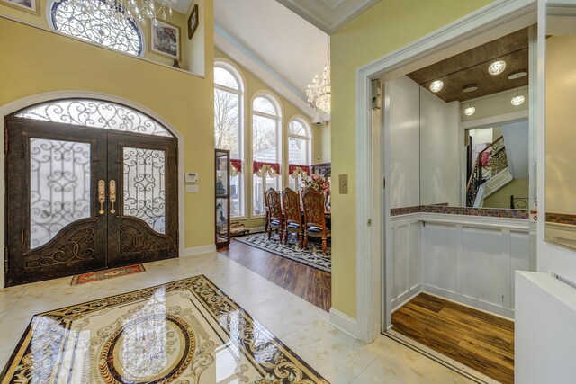 entryway featuring light tile patterned floors, french doors, plenty of natural light, and a notable chandelier