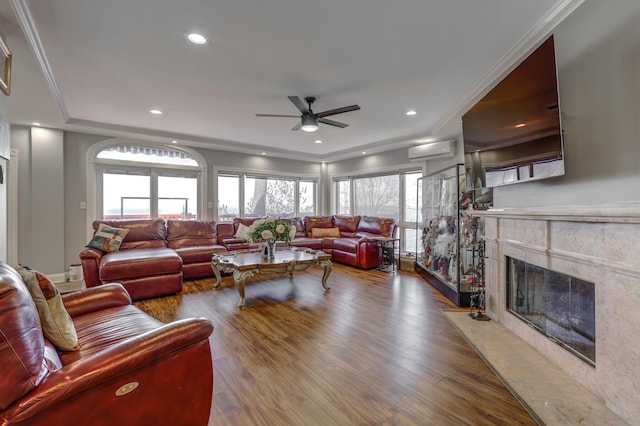 living room featuring a wall unit AC, ornamental molding, dark wood-style flooring, a fireplace, and recessed lighting