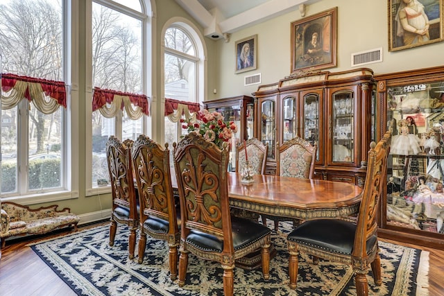 dining room featuring visible vents, a wealth of natural light, and wood finished floors