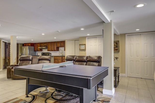 rec room with baseboards, a sink, and recessed lighting