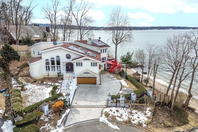 view of front of home with a fenced front yard and decorative driveway