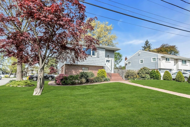 view of front of house with brick siding and a front lawn