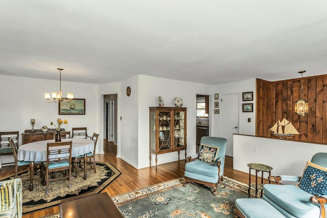 living room featuring an inviting chandelier, baseboards, and wood finished floors
