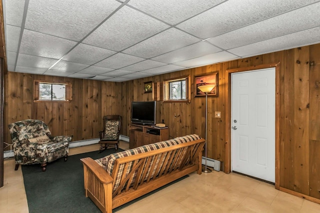 living area featuring wood walls, a wealth of natural light, and a baseboard radiator