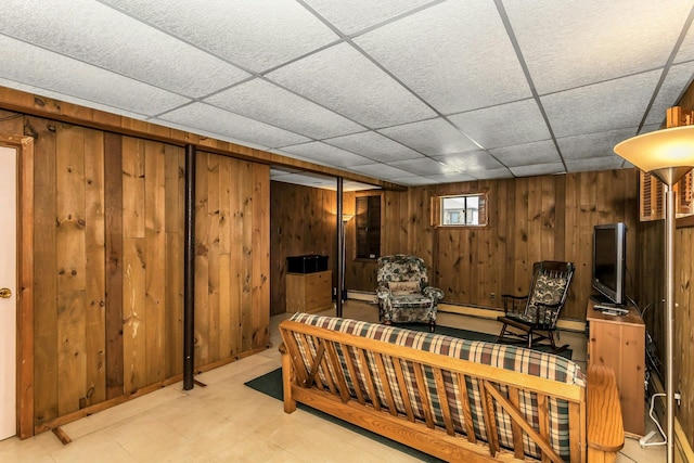interior space featuring tile patterned floors, a baseboard heating unit, wood walls, and a paneled ceiling