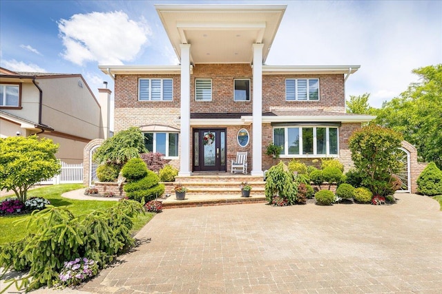 view of front of property featuring brick siding and fence