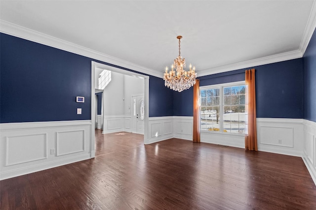 unfurnished dining area with dark wood-style flooring, a notable chandelier, visible vents, ornamental molding, and wainscoting