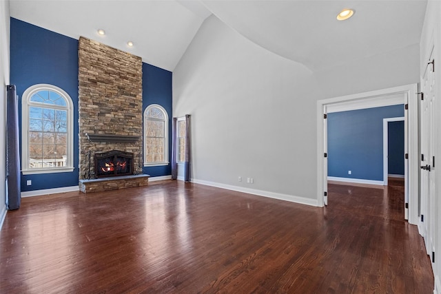 unfurnished living room with baseboards, a fireplace, high vaulted ceiling, and dark wood-type flooring