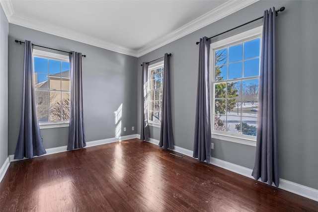 spare room with a wealth of natural light, baseboards, and wood finished floors