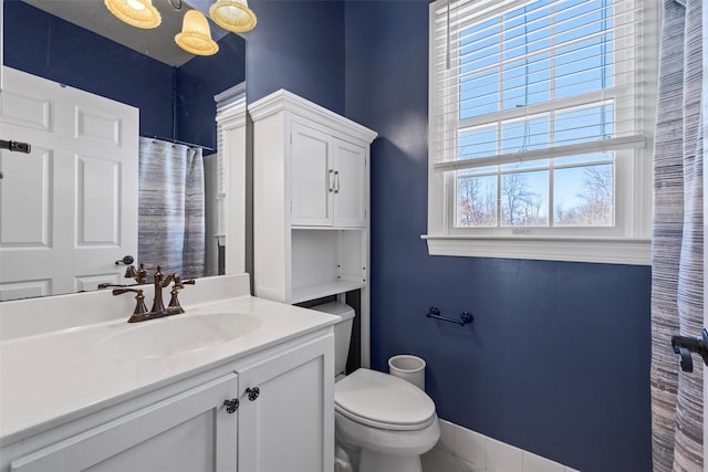 full bathroom featuring vanity, toilet, and baseboards