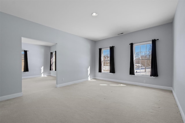 empty room featuring recessed lighting, light colored carpet, visible vents, and baseboards