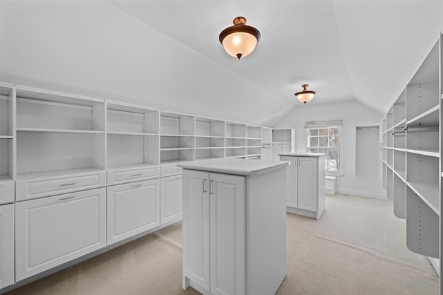 walk in closet featuring lofted ceiling and light colored carpet