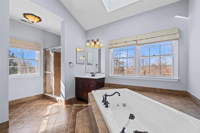 full bath featuring vanity, baseboards, tile patterned floors, a tub with jets, and lofted ceiling with skylight