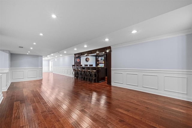 interior space featuring ornamental molding, indoor bar, dark wood finished floors, and recessed lighting