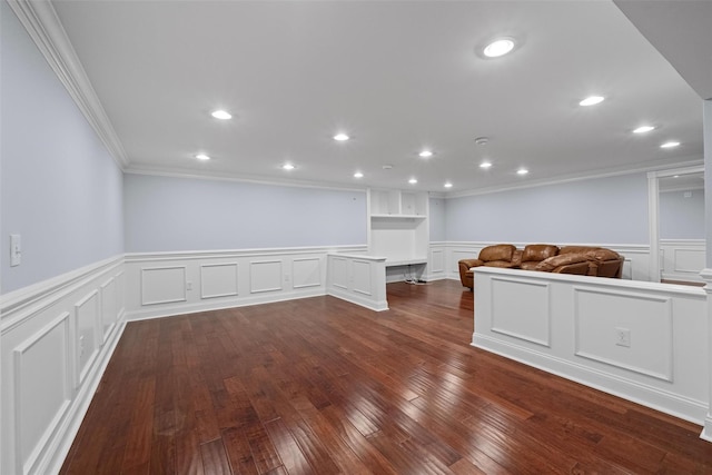 interior space with recessed lighting, a wainscoted wall, dark wood-style floors, built in desk, and crown molding