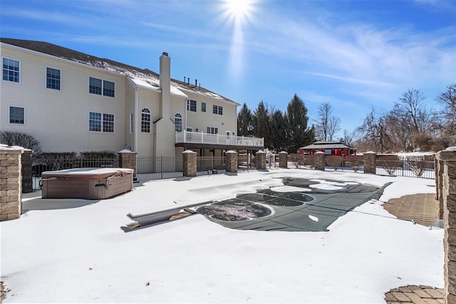 snowy yard with fence and a hot tub