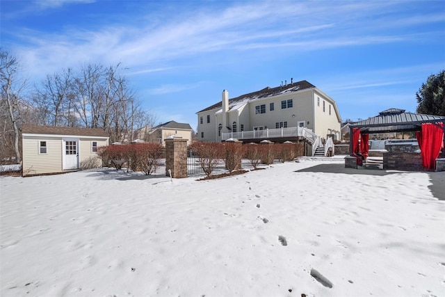 snowy yard with an outdoor structure, stairway, and a gazebo