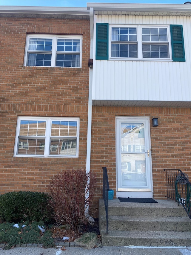 view of exterior entry featuring brick siding