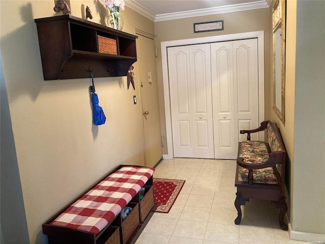 interior space featuring light tile patterned floors, a closet, and crown molding