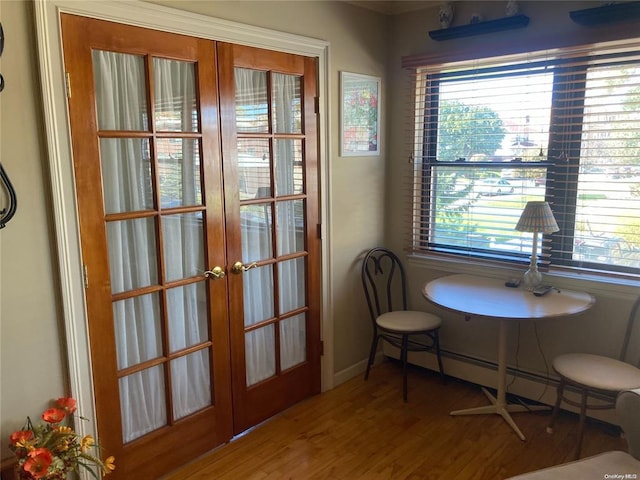 interior space featuring french doors, baseboard heating, wood finished floors, and baseboards