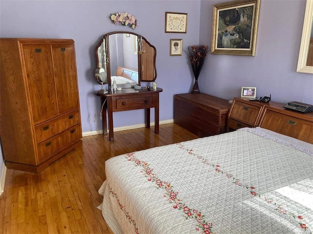 bedroom with wood finished floors and baseboards