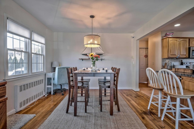 dining room with wood finished floors, recessed lighting, baseboards, and radiator heating unit