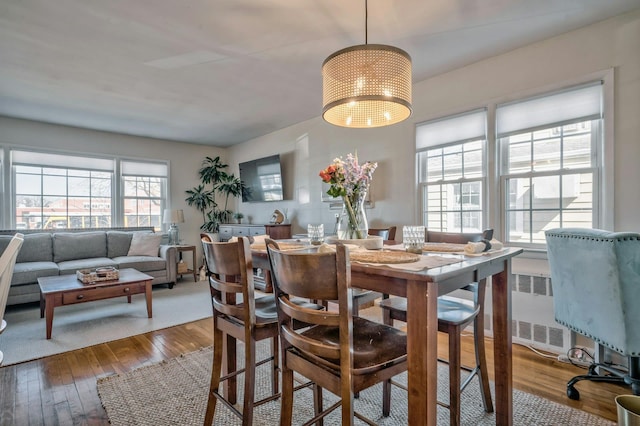 dining space with wood-type flooring and a chandelier