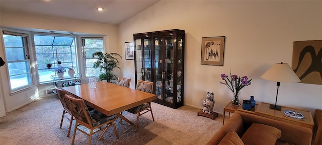 dining area featuring a wealth of natural light, carpet flooring, and vaulted ceiling