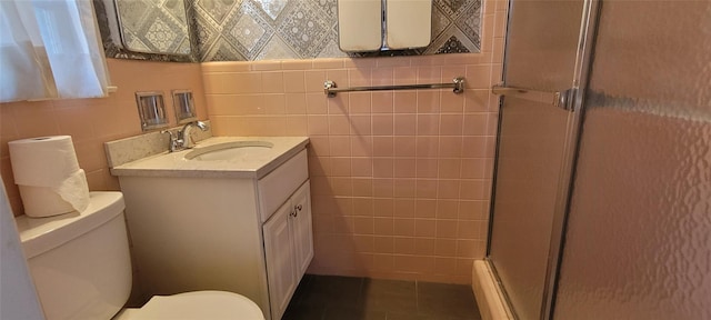 full bath with toilet, a shower with door, tile patterned floors, vanity, and tile walls