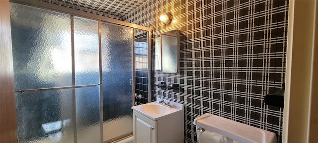 full bathroom featuring a shower stall, vanity, and tile walls