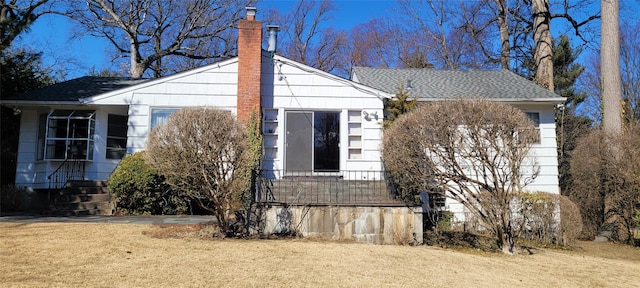 view of home's exterior with a chimney and a lawn