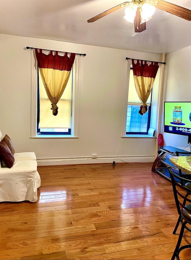 interior space with light wood finished floors, ceiling fan, and baseboards