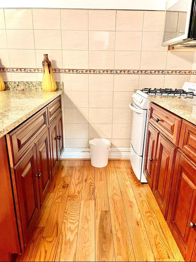 bathroom featuring decorative backsplash, wood finished floors, and vanity