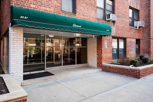 doorway to property with brick siding and cooling unit