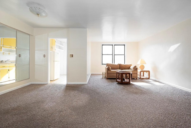 sitting room featuring carpet floors and baseboards