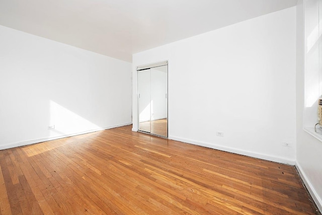 interior space with a closet, baseboards, and wood finished floors