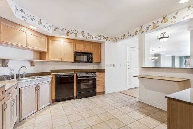 kitchen featuring a notable chandelier, light tile patterned flooring, a sink, black appliances, and baseboards