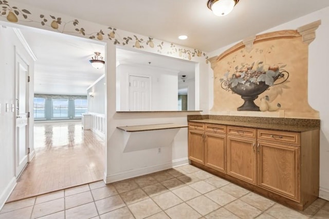 kitchen with brown cabinets, baseboards, and light tile patterned floors