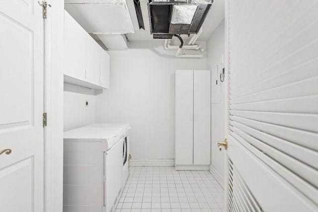 laundry room with cabinet space, baseboards, and light tile patterned flooring