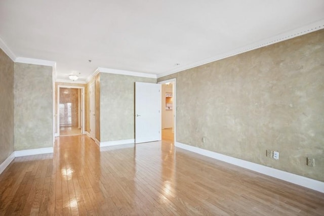 unfurnished room with baseboards, crown molding, and light wood finished floors