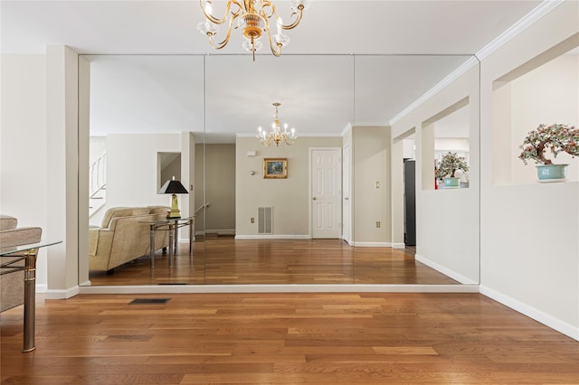 dining room featuring ornamental molding, wood finished floors, visible vents, and an inviting chandelier