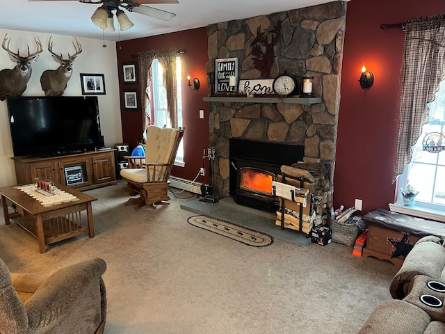 living area featuring ceiling fan, carpet flooring, and a stone fireplace