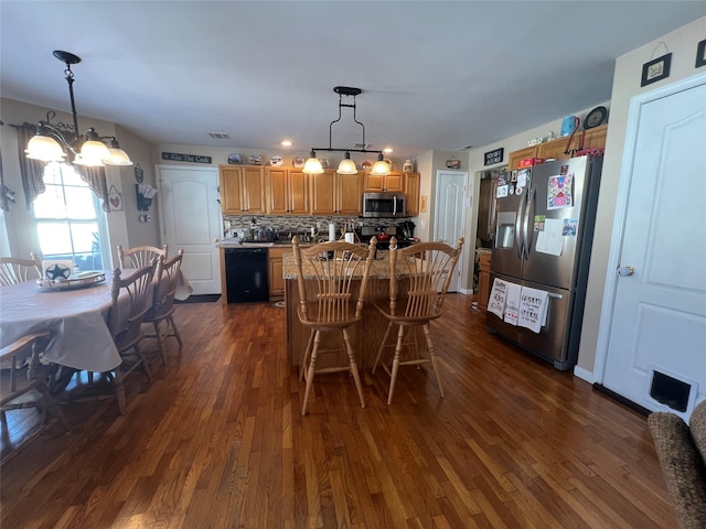 dining area featuring dark wood-style flooring, visible vents, and an inviting chandelier