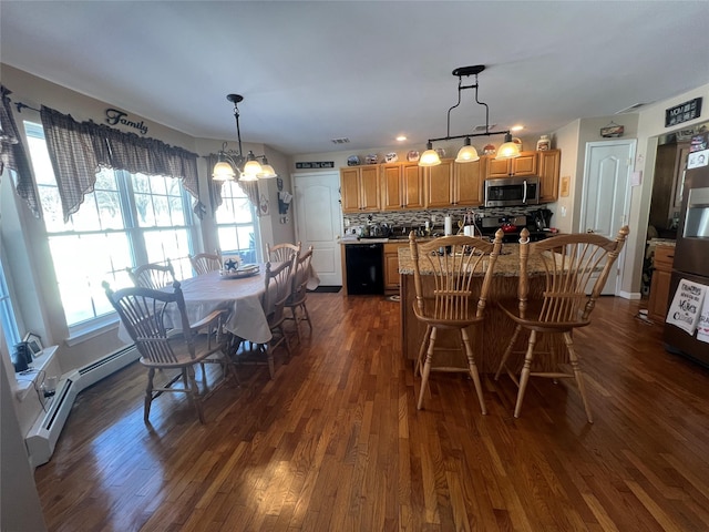 dining area featuring an inviting chandelier, a baseboard heating unit, and dark wood-type flooring