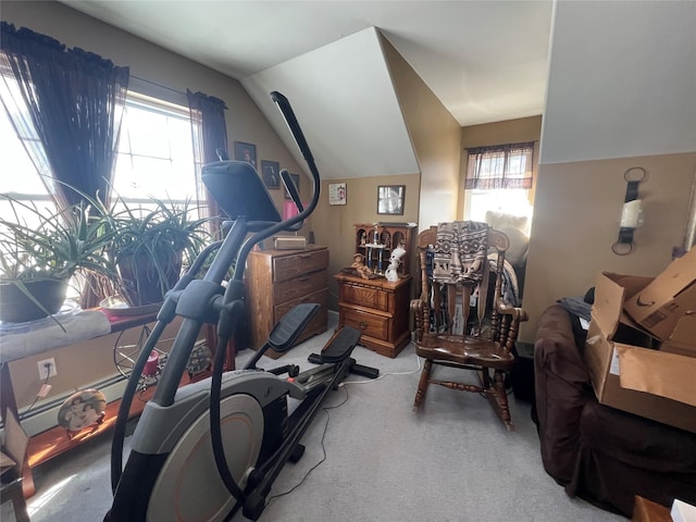 exercise room with lofted ceiling and light carpet