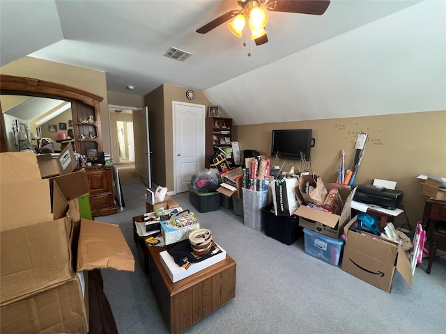 carpeted living room with a ceiling fan, visible vents, and vaulted ceiling